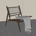Lounge Chair Wooden Frame Woven Design With Gray Blanket Draped Over Minimalist White Wall