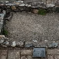 Old Stone Wall Enclosed Space Featuring Gravel Ground Brick Paving and Small Grass