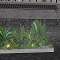 Lush Green Plants in Rectangular Planter with Carved Gray Brick Wall Stones and Bottom Lighting