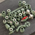 Green Pipe Fittings With Various Connectors Valves And Flanges On Dark Table