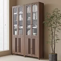 Tall Wooden Bookcase With Glass Doors And Books In Bright Room With Green Plant