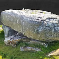Outdoor Stone Structure With Large Top Slab And Supporting Stones On Green Grass