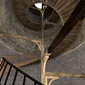 Spiral Staircase In Stone Tower Interior With Wooden Steps And Support Beams