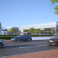 Modern Glass Facade Office Building With Greenery Along Street And Cars Driving By