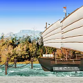 Scenic Park Landscape with Sailboat Model Colorful Trees Distant Mountains Blue Sky and Calm Water