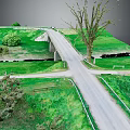 Winding Country Road And Small Bridge Through Lush Green Meadow With Trees