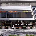 Modern Commercial Street Outdoor Area With Storefronts Umbrellas Plants And Pedestrians