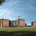 Red Multi Story School Building With Clock Tower Green Lawn And Students Outdoor Area
