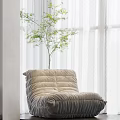 Beige Cozy Bean Bag Chair By Window With White Curtains And Green Plant