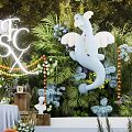 Floral Display With Green Foliage Background White Elephant Decoration And Illuminated Letters