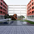 Modern Architectural Courtyard With Red Buildings Sculpture Water Ponds Green Lawn And Paved Ground