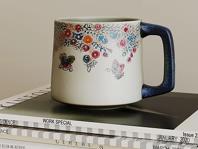 Ceramic Mug with Colorful Floral Patterns Butterflies and Blue Handle Placed On Stacked Magazines 3d model