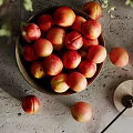 Fresh Ripe Nectarines in a Bowl on Gray Countertop with Some Scattered Around