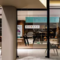 Modern Dessert Shop Exterior With Glass Facade Signboard Warm Lighting And Interior Seating