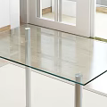 Modern Glass Top Dining Table With Silver Metal Legs Near Windows In Bright Indoor Space