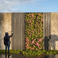 Stunning Living Plant Wall With Pink Flowers Against Gray Concrete Wall As People Take