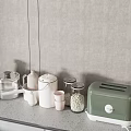 Modern Kitchenware on Gray Countertop with Silver Pot White Jars Pink Cups and Green Toaster