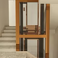 Modern Indoor Elevator With Glass Door And Bronze Frame Near Staircase