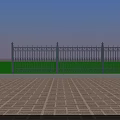 Ornate Iron Fence With Spiked Top Green Base And Brick Floor Against Blue Sky