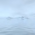 Scenic View of Calm Water with Gentle Ripples Distant Misty Islands in Hazy Light Blue