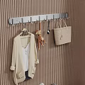 Wall Mounted Hook With Hanging Coat Stuffed Toy Spoon And Handbag On Brown Striped Wall