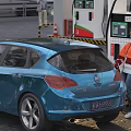 Woman in Orange Jacket Refueling Blue Car at Gas Station with Fuel Dispenser