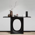 Modern Black Console Table With Circular Cutout Design And Decorative Items On Wooden Floor