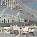 Modern Architectural Landscape With Glass Facade Blue Lighting Storefronts And Urban Pedestrian View