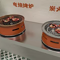 Electric And Charcoal Barbecue Grills Two Orange Cookers With Food On Countertop