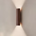 Dark Brown Wooden Vertical Wall Lamp with Soft Lighting Effect on Light Wall