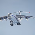 Large Military Transport Aircraft In Flight With Extended Landing Gear And Blue Stripes