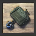 Green Tactical Pouch With Tape Rolls Placed On Wooden Cutting Board