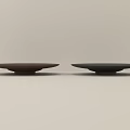 Two Brown and Black Ceramic Plates with Minimalist Design on Light Background