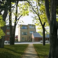 Modern Multistory Office Building With Brick And Glass Exterior Surrounded By Trees Grass Pathway