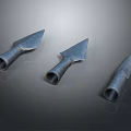 Three Metallic Arrowheads With Shiny Surfaces Displayed On Dark Background
