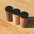 Three Brown And Beige Spice Jars With Black Lids On Wooden Tabletop