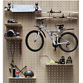 Organized Wall Mounted Sports Equipment Including Bicycles Helmets And Tennis Rackets On Pegboard Wall