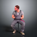 Man Sitting On Chair In Gray T Shirt And Gray Overalls With Red Details Beige Shoes On Gray Gradient Background