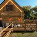 Wooden Coffee House With Black Roof Terrace Chairs Tables Green Lawn And Trees