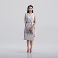 Elegant Woman In Sleeveless Polka Dot Dress With Beige Handbag And High Heels Standing Gracefully