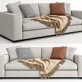 Light Grey Two Seater Sofa With Black White Checkered Brown Pillows And Beige Fringed Blanket