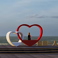 Seaside Ocean View With Red And White Heart Shaped Sculptures And Person Sitting