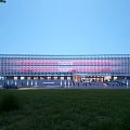 Modern Library Building With Striped Glass Facade Green Lawn Trees Front Entrance And Illuminated Exterior