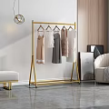 Gold Floor Standing Clothes Rack With Hanging Dresses And Modern Interior Decor