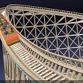 Roller Coaster Ride with Curved Track and Lattice Structure under Night Sky with Passengers