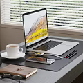 Open Laptop on Desk by Window with Coffee Cup Clock Notebook Glasses Pens and Smartphone