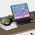 Tablet With Keyboard Mouse And Earbuds On Wooden Desk With Books Plant And Eyeglasses