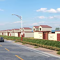 Row of Houses with Red Roofs Along Roadside Featuring Street Lamps Greenery and Black Car
