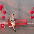 Red Public Bench With Heart Shaped Balloons And Gift Boxes Against Gray Wall