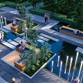 Water Fountain in Urban Park with Stone Paths Greenery and Seating Areas